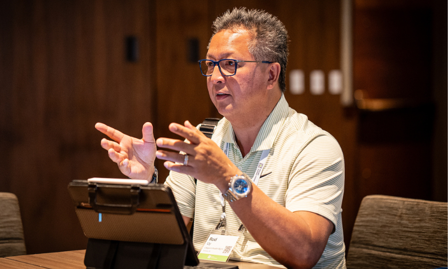 A man with glasses speaks on a laptop, illustrating his position as an Advisor in Investor Management.