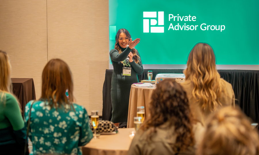 A woman presenting at a Private Advisor Group event, engaging the audience with insightful information on membership benefits.