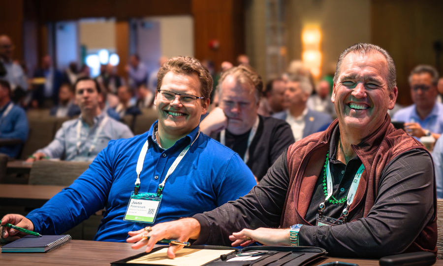 Two men at a conference table, smiling, representing collaboration in the Private Advisor Group